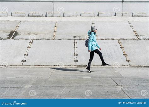 Opini N Del Perfil Una Muchacha En Una Chaqueta Azul Est Saltando En