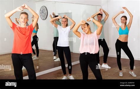 Alegres adolescentes niños y niñas bailando coreografía de grupo