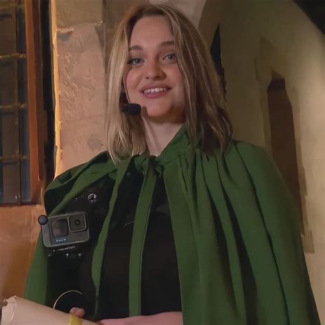 A Woman Wearing A Green Cape And Holding A Banana