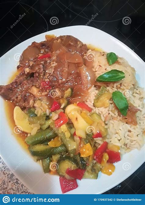 Un Cerdo Asado Con Arroz Y Verduras En Salsa Foto De Archivo Imagen