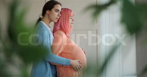 Woman And Her Pregnant Girlfriend Looking Out Through Window Stock Video Colourbox