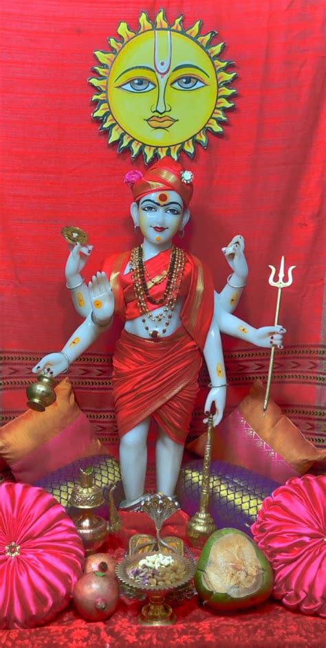 A Statue Of The Hindu God Ganesha In Front Of A Red Backdrop With Pink