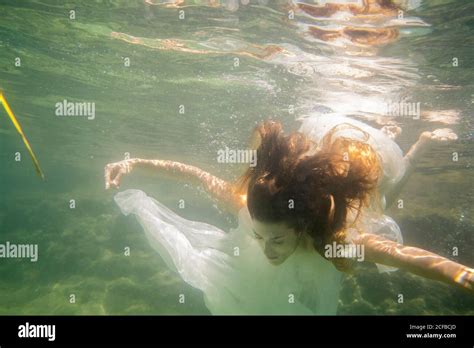 A Nude Woman Dances And Dives With Transparent Fabrics Under The Sea