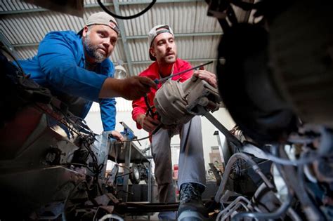 Premium Photo Mechanics Repairing Car In Workshop