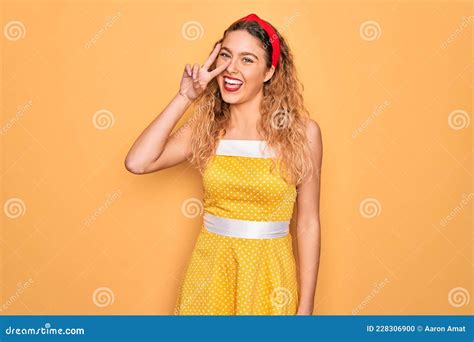 Belle Blonde Pinup Femme Aux Yeux Bleus Portant Le Diadem Debout Sur Fond Jaune Faisant Symbole