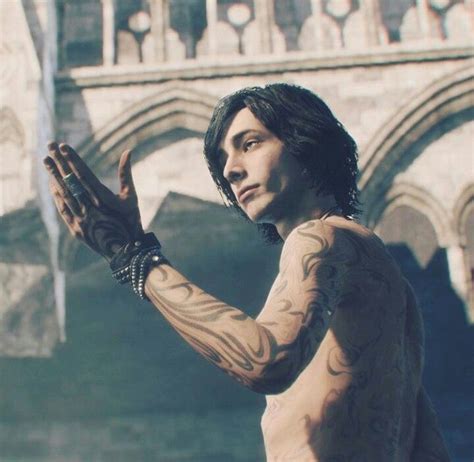 A Man With Tattoos Holding His Hands Up In Front Of An Old Stone