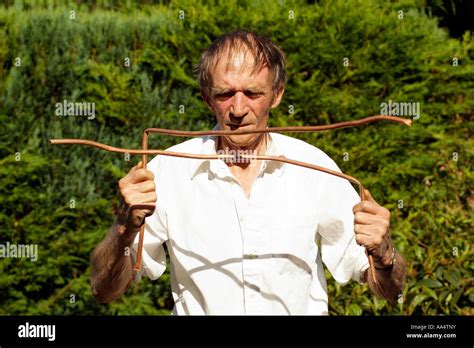 Water Diviner Man Using Copper Divining Rods To Trace Water Flow