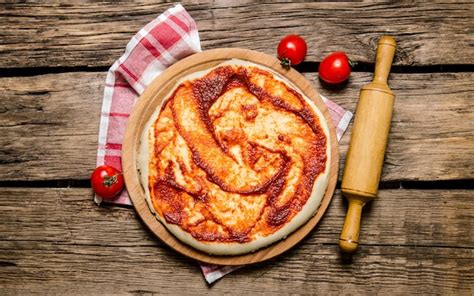 Premium Photo The Rolled Out Pizza Dough With Tomato Sauce And With A