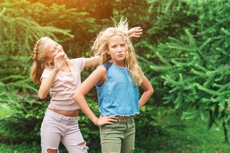 Les Filles Heureuses De Jumeaux Ont L Amusement Ensemble Dans Un Parc