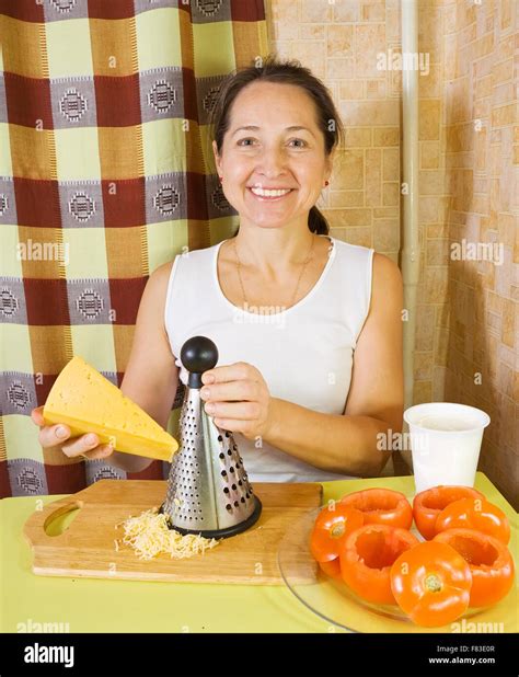 Mature Woman Grating Cheese In Her Kitchen See In Series Stages Of