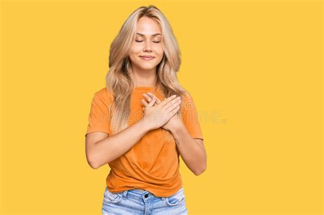 Young Blonde Girl Wearing Casual Clothes Smiling With Hands On Chest