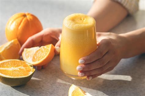 Free Photo Freshly Squeezed Orange Juice In Female Hands Close Up