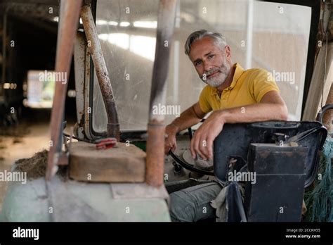 Portrait Of A Mature Farmer On A Tractor Stock Photo Alamy