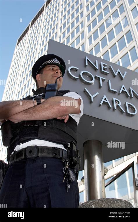 Policeman officer outside New Scotland Yard building with rotating logo ...