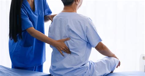 Female physical therapist doing physical therapy for adult patient at