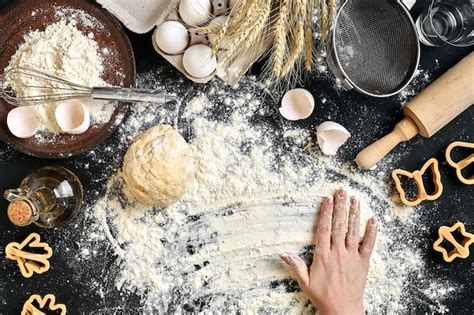 Las Manos De La Mujer Amasan La Masa En La Mesa Con Huevos De Harina E