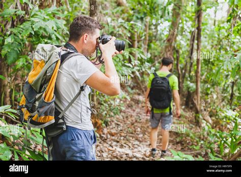 Nature Photographer In Tropical Jungle Group Of Tourists Hiking In The