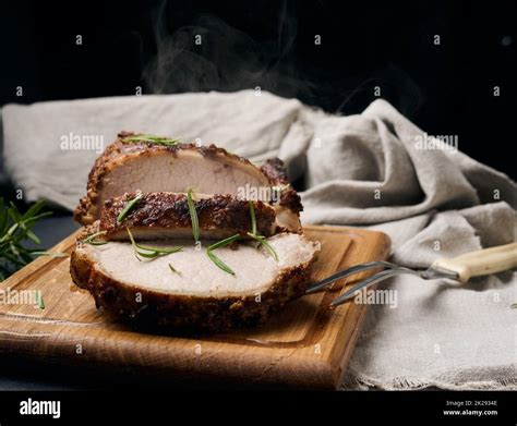 Baked Piece Of Pork Meat In Spices On A Wooden Board Cut Into Pieces