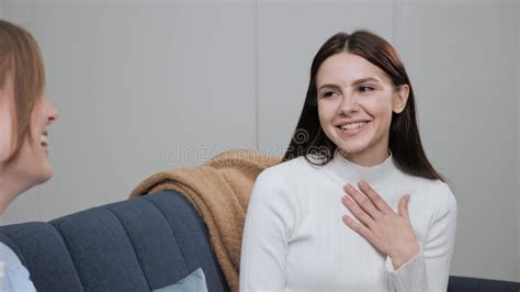 Two Best Girlfriends Are Sitting On The Couch Talking Gossiping