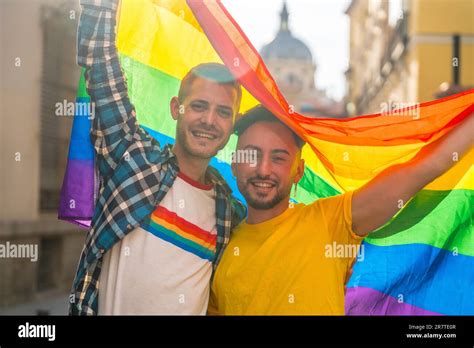 Portrait Of Gay Male Couple With Rainbow Flag At Pride Party In The City Lgbt Concept Stock