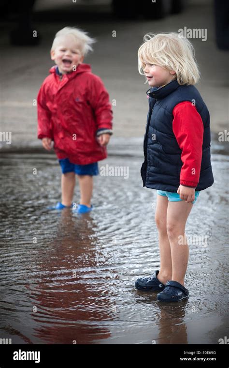 Two Young Boys Playing And Splashing In A Puddle Stock Photo Alamy