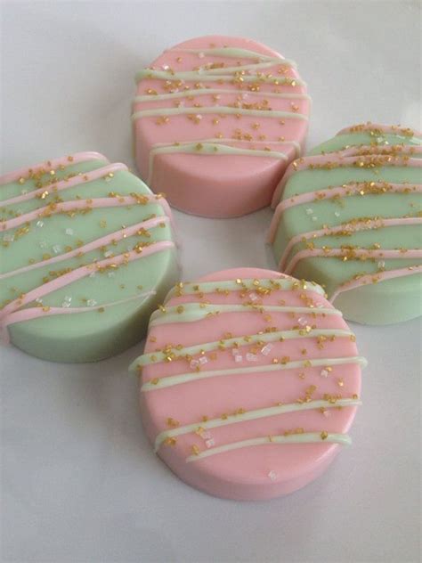 Four Decorated Cookies Sitting On Top Of A White Table