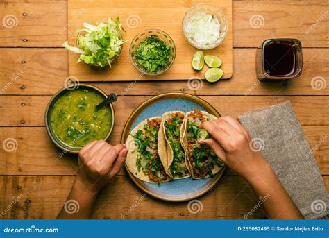 Woman S Hand Holding A Taco Of Marinated Meat Plate With Tacos Sauce