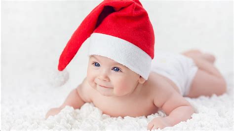 Blue Eyes Cute Baby Is Lying Down On White Cloth Wearing Santa Claus