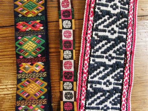 Two Different Colored Belts Sitting On Top Of A Wooden Table