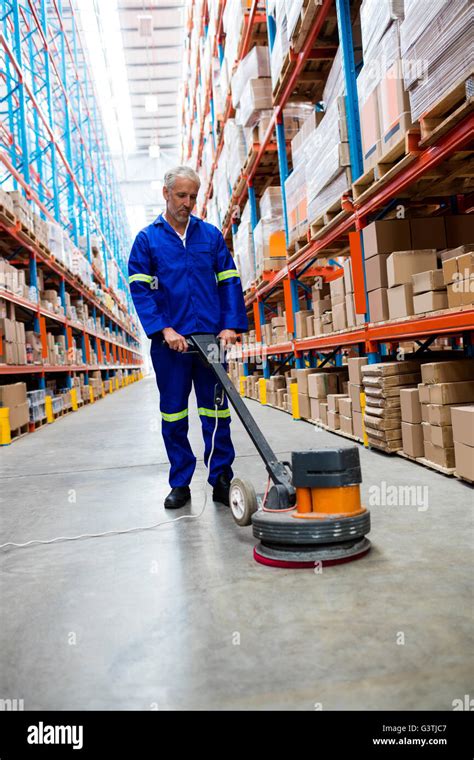 Man cleaning warehouse floor with machine Stock Photo - Alamy