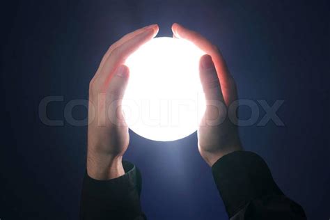 Hands Holding A Glowing Sphere Shaped Object Stock Photo Colourbox