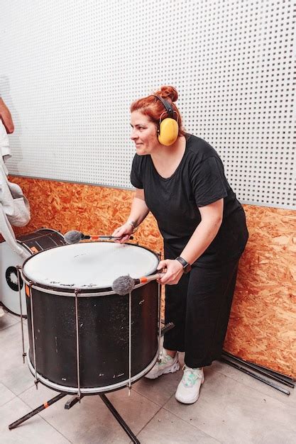 Mujer Tocando El Tambor Con Protectores Auditivos Foto Premium