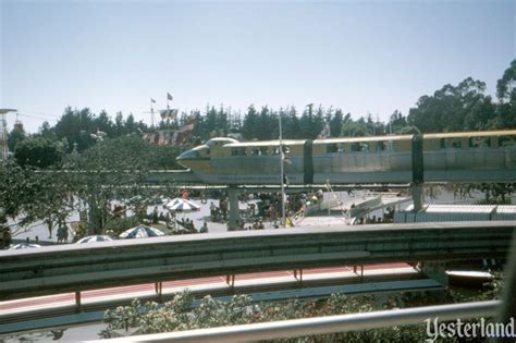 The Train Is Traveling Down The Tracks Near Many Trees And People