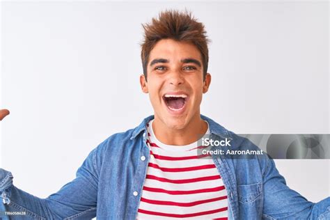 Young Handsome Man Wearing Striped Tshirt And Denim Shirt Over Isolated