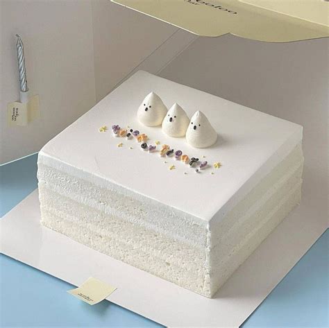 There Is A Cake With Three White Birds On The Top And Two Smaller Ones