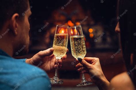 Premium Photo Young Man And Woman Touching Glasses With Champagne