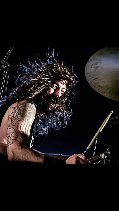 a man with long hair playing drums on stage