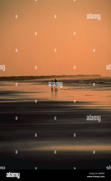 Couple walking on the beach silhouette Stock Photo - Alamy