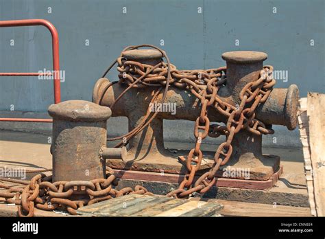 Bolardo de hierro oxidado del barco enredado cadenas metálicas