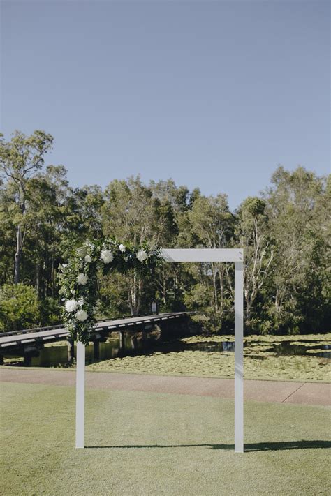 White wooden plank archway with fresh corner greenery & floral