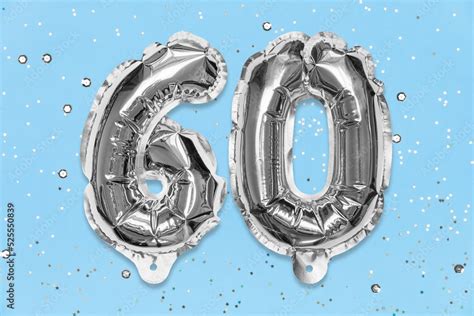 Silver Foil Balloon Number Digit Sixty On A Blue Background With