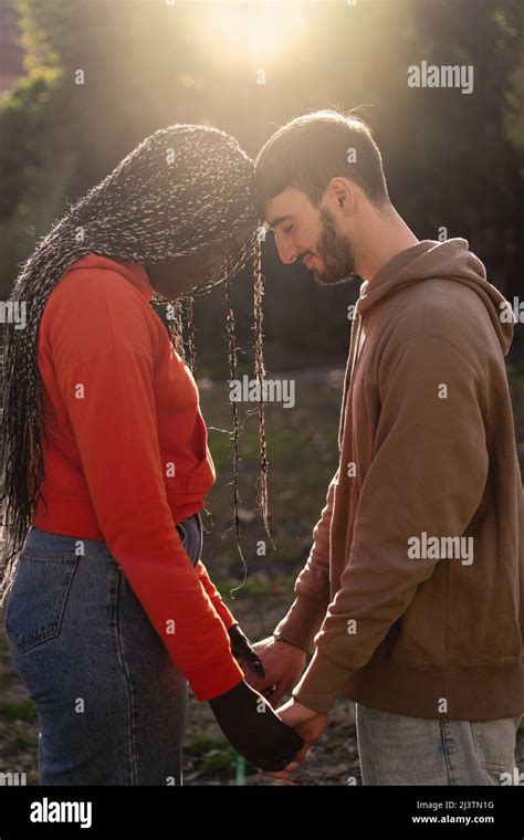 Side View Of Young Bonding Biracial Couple Touching Foreheads Enjoying