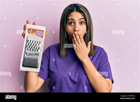 Giovane Donna Latina Che Regge Il Grater Coprendo La Bocca Con La Mano Scioccata E Impaurita