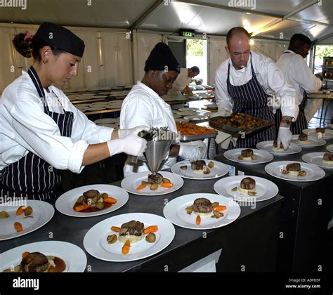 Chefs Working In Large Kitchen Preparing Banquet Dinner Stock Photo