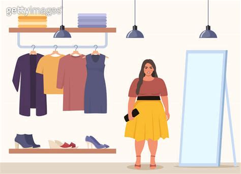 Woman Stands Near Clothes Rack And Mirror Chooses Clothes In Fashion