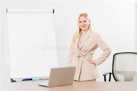 A Blonde In A Suit In An Office With A Board For Meetings Desktop And Laptop Stock Image