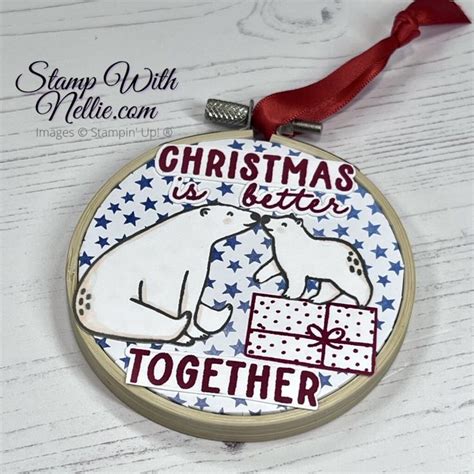 A Christmas Ornament Hanging From A Red Ribbon On Top Of A White Table