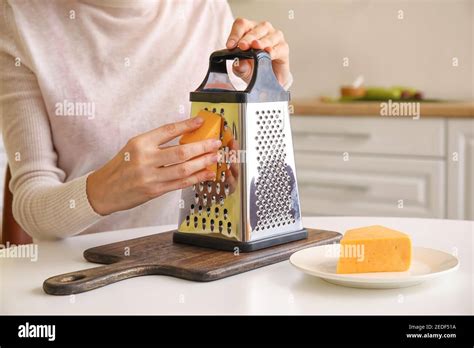 Woman Grating Cheese On Kitchen Table Stock Photo Alamy