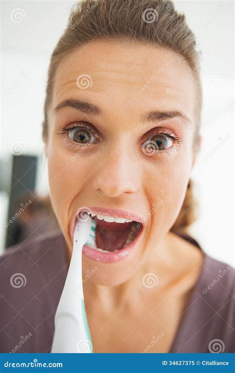 Funny Portrait Of Young Woman Intensively Brushing Teeth Stock Image