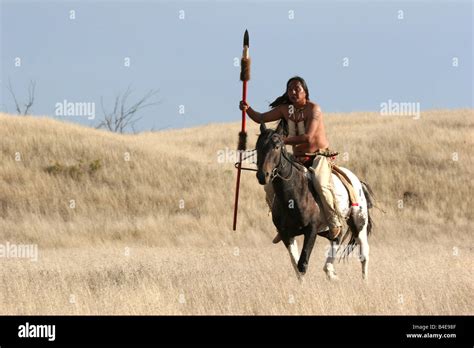 A Native American Lakota Indian riding horseback in the prairie of ...